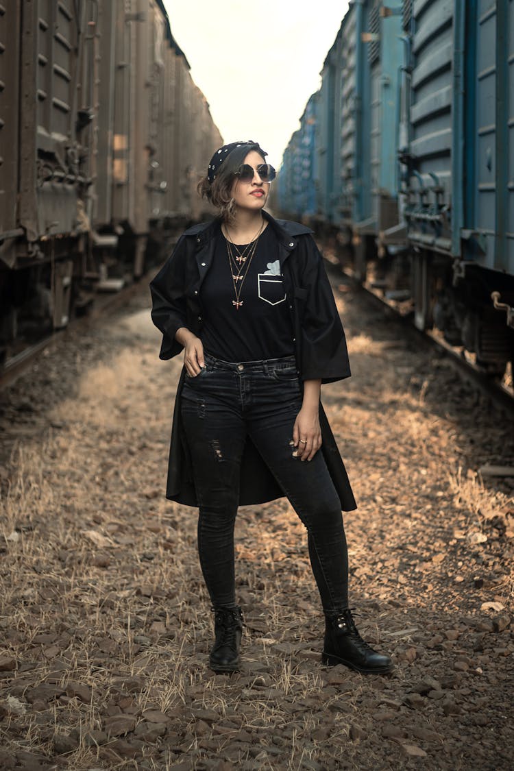 Woman In Black Coat Standing Near Cargo Trains