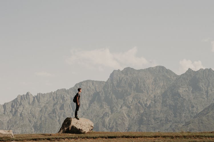 Man Standing On A Rock In Mountains 