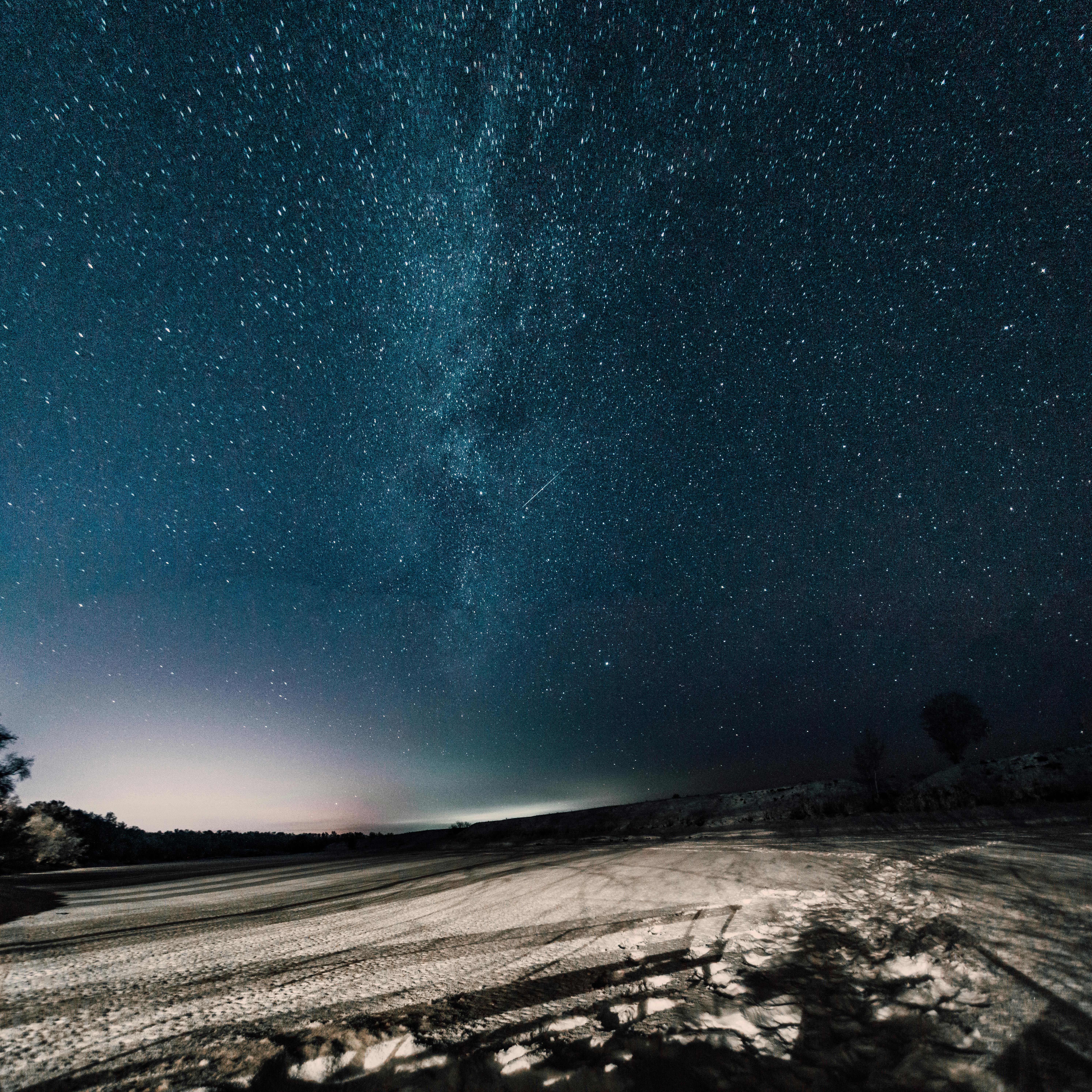 A breathtaking view of a starry night sky over a desert landscape, showcasing the Milky Way.