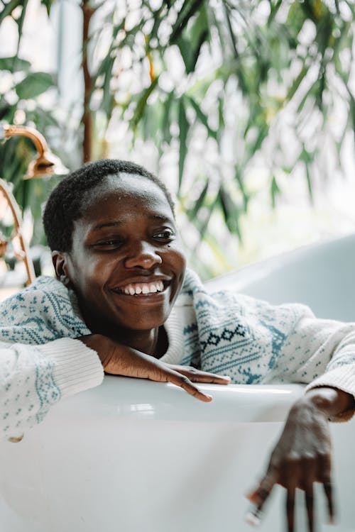 Smiling Woman in White Sweater Sitting on White Chair