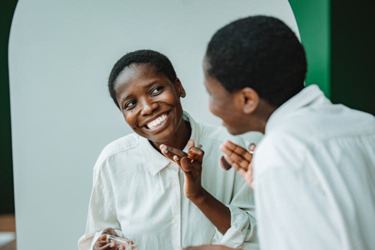 A Person Smiling While Looking At The Mirror