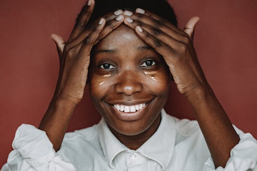 A joyful woman applies under eye patches during her morning skincare routine.