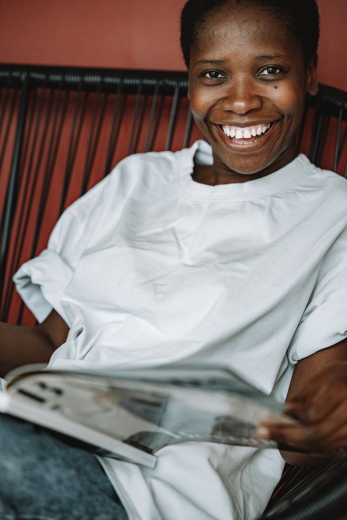 Manager smiling while reviewing her team notes — photo by ROMAN ODINTSOV on Pexels