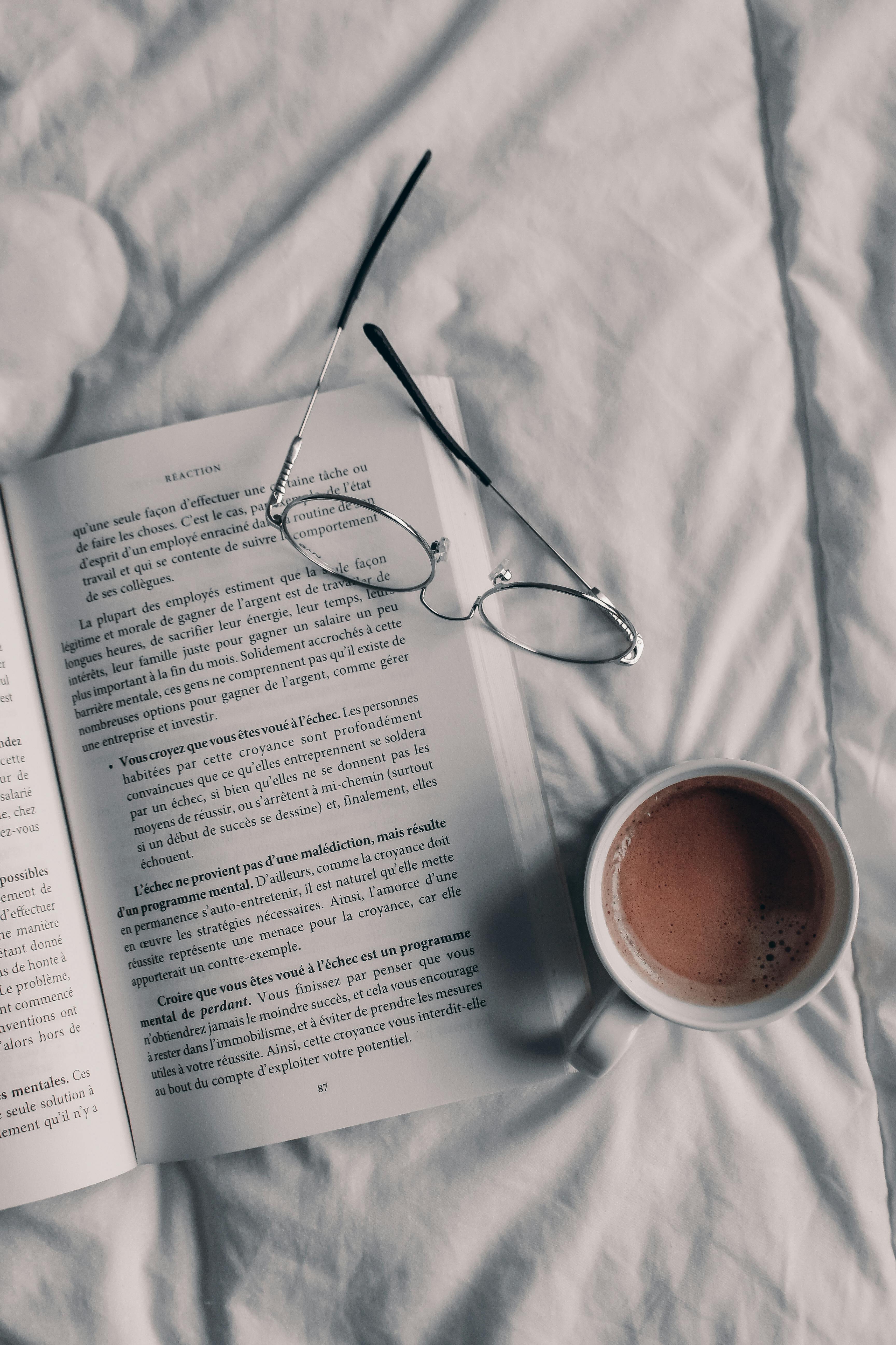 Hand Touching Coffee Cup on Bed · Free Stock Photo