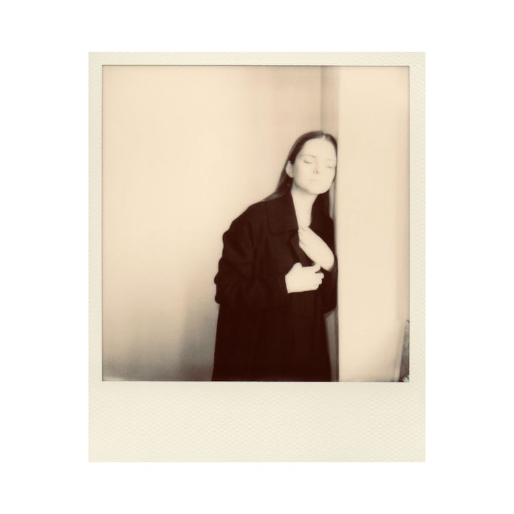 Sepia Toned Photograph Of A Woman Leaning Against A Wall