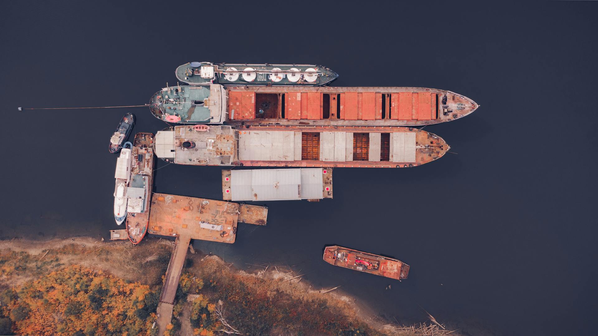Drone shot showcasing docked ships at Volgograd port, Russia with a fall backdrop.