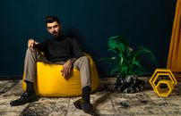 Man in Black Long Sleeve Shirt Sitting on Yellow Chair