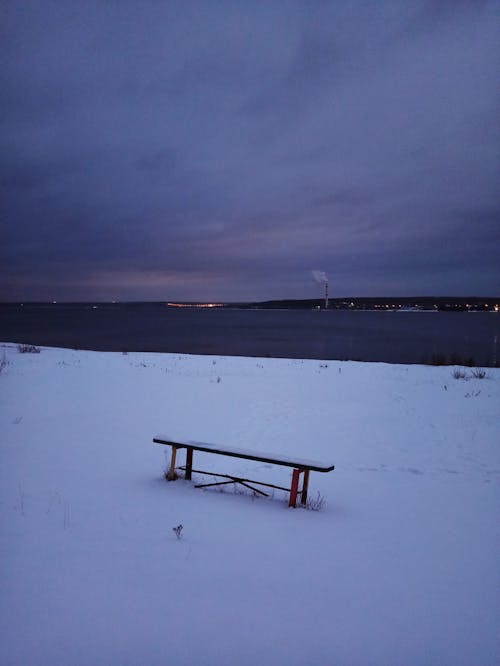 A Bench on a Snow Covered Ground During Winter