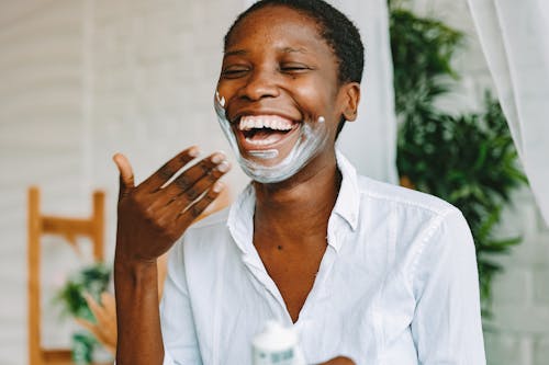 Happy Woman Applying Face Cream 