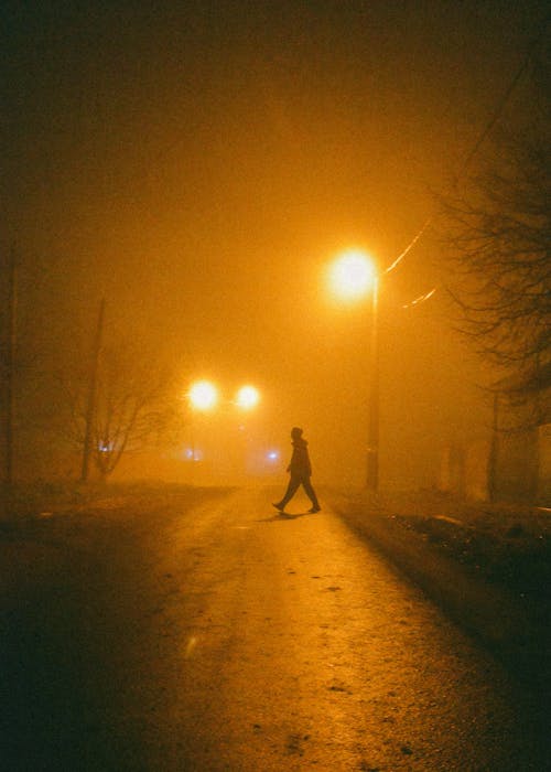 Free A Person Crossing a Lighted Road  Stock Photo