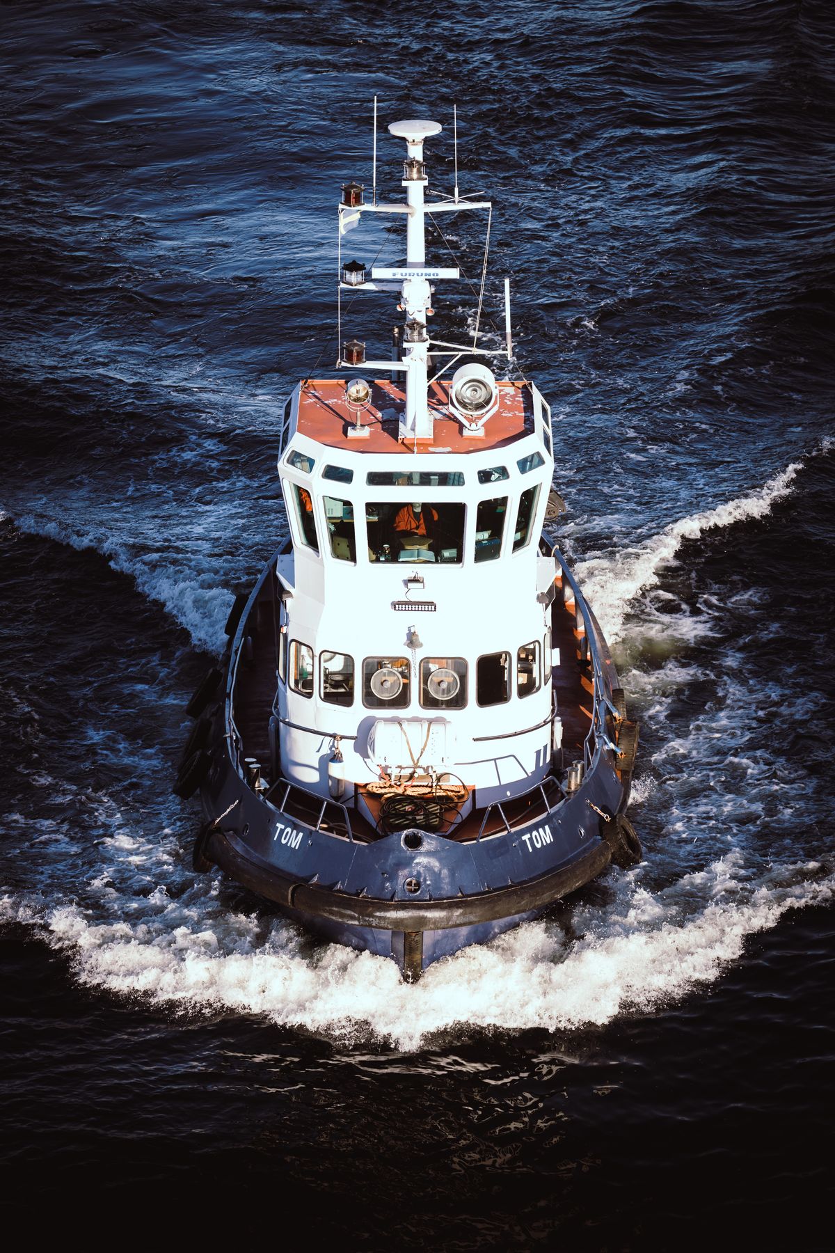 Vessel cruising through ocean waves under clear blue skies
