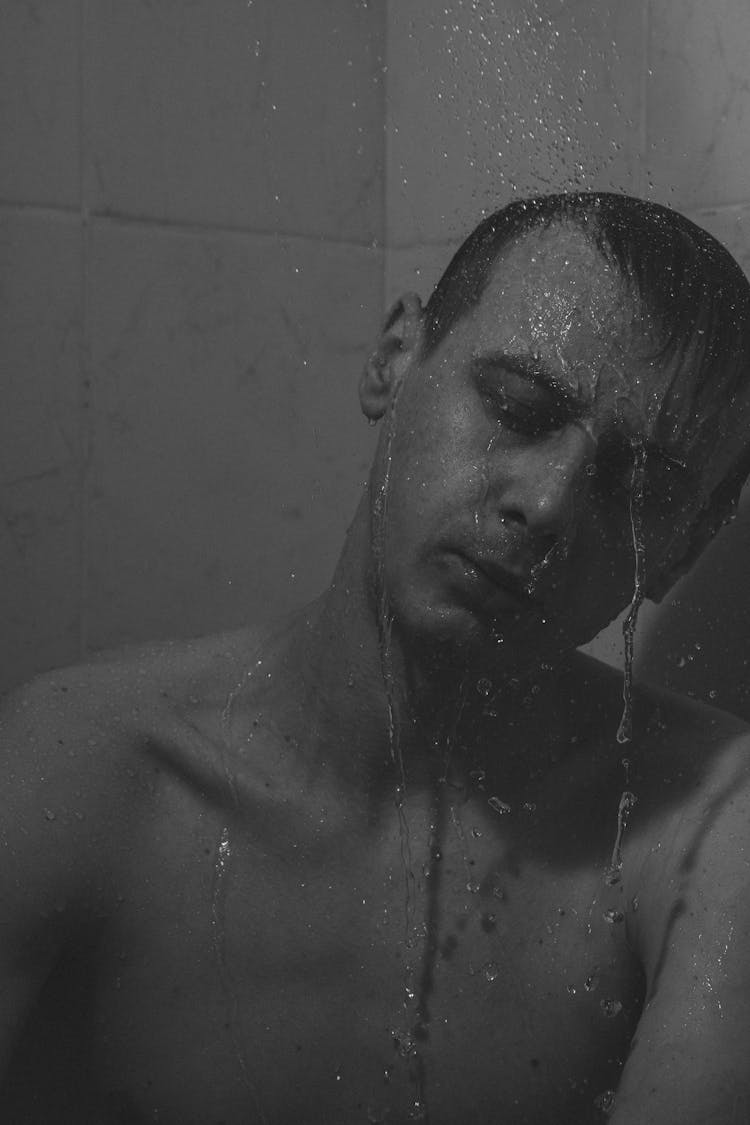 Grayscale Photo Of A Man Showering