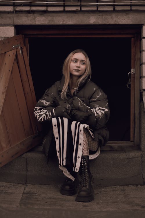 Woman Sitting in Open Cellar Doors