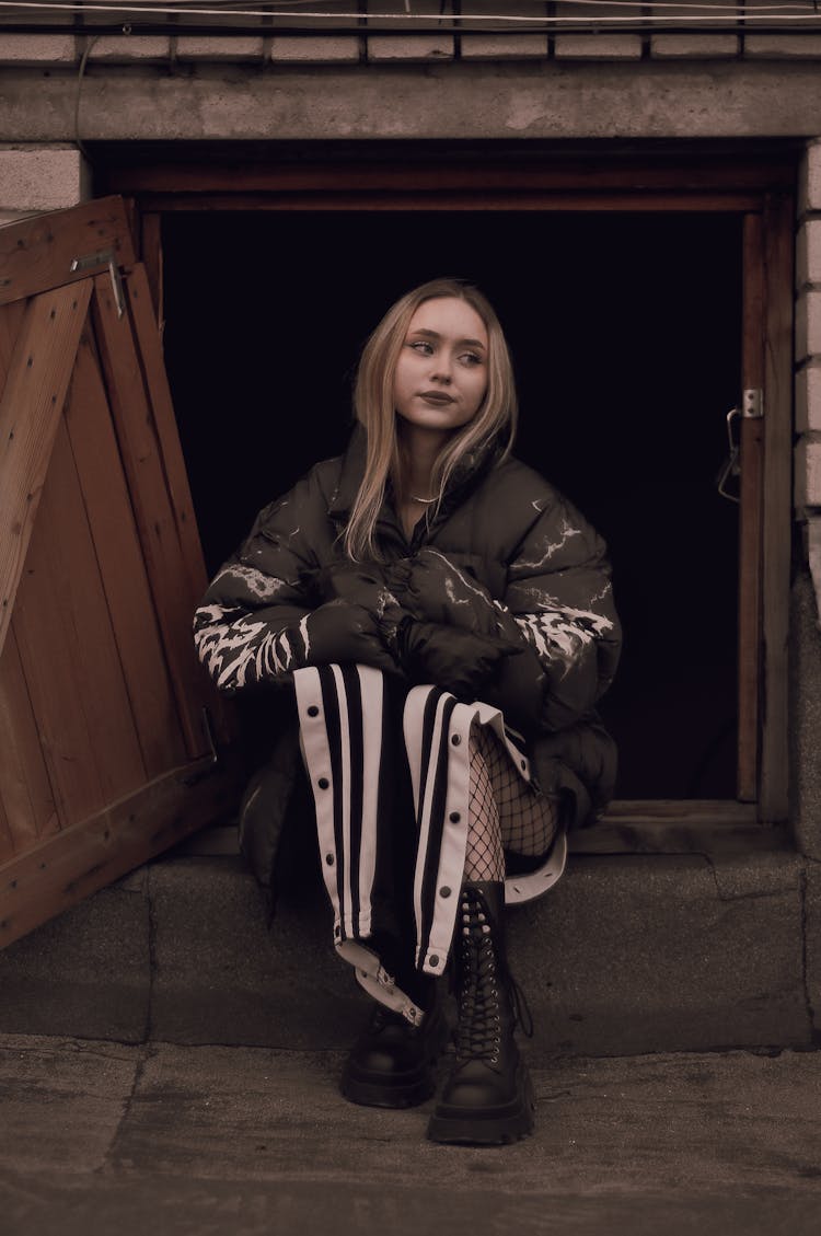 Woman Sitting In Open Cellar Doors