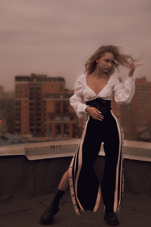 Woman in Black and White Outfit Holding Her Hair Pose 