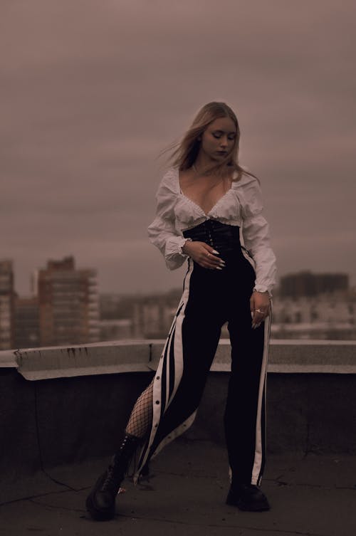 A Woman in Black and White Jumpsuit Standing on the Rooftop