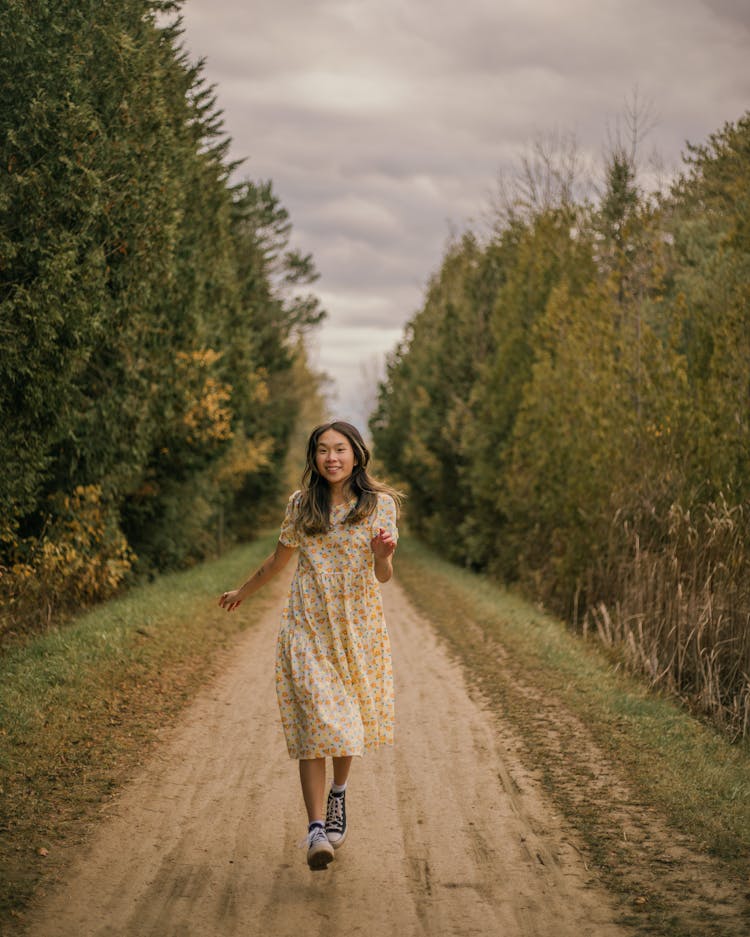 Happy Woman Hopping On Unpaved Road