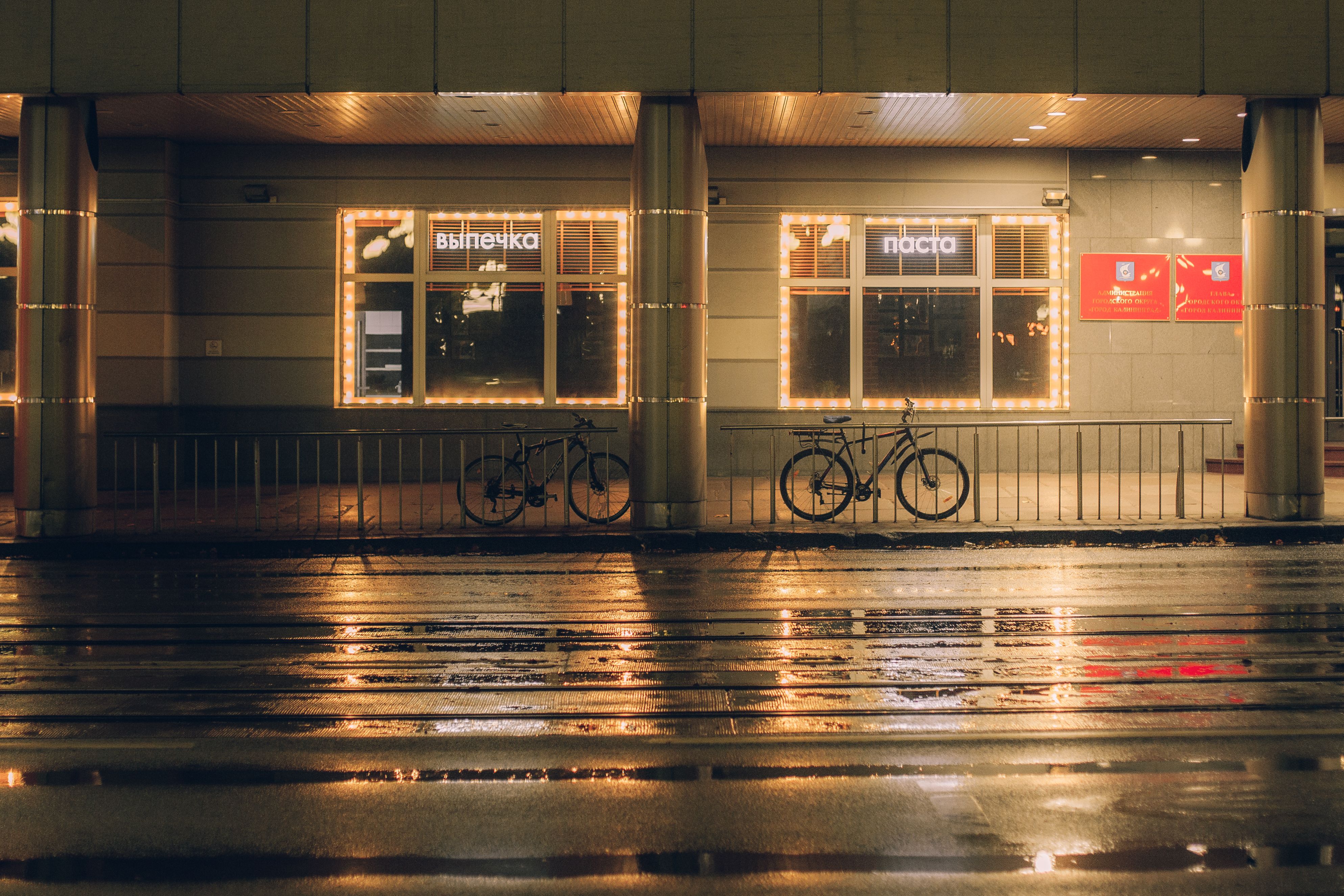 pressure washing a commercial storefront sidewalk at dawn, wet clean concrete, glass windows and signage