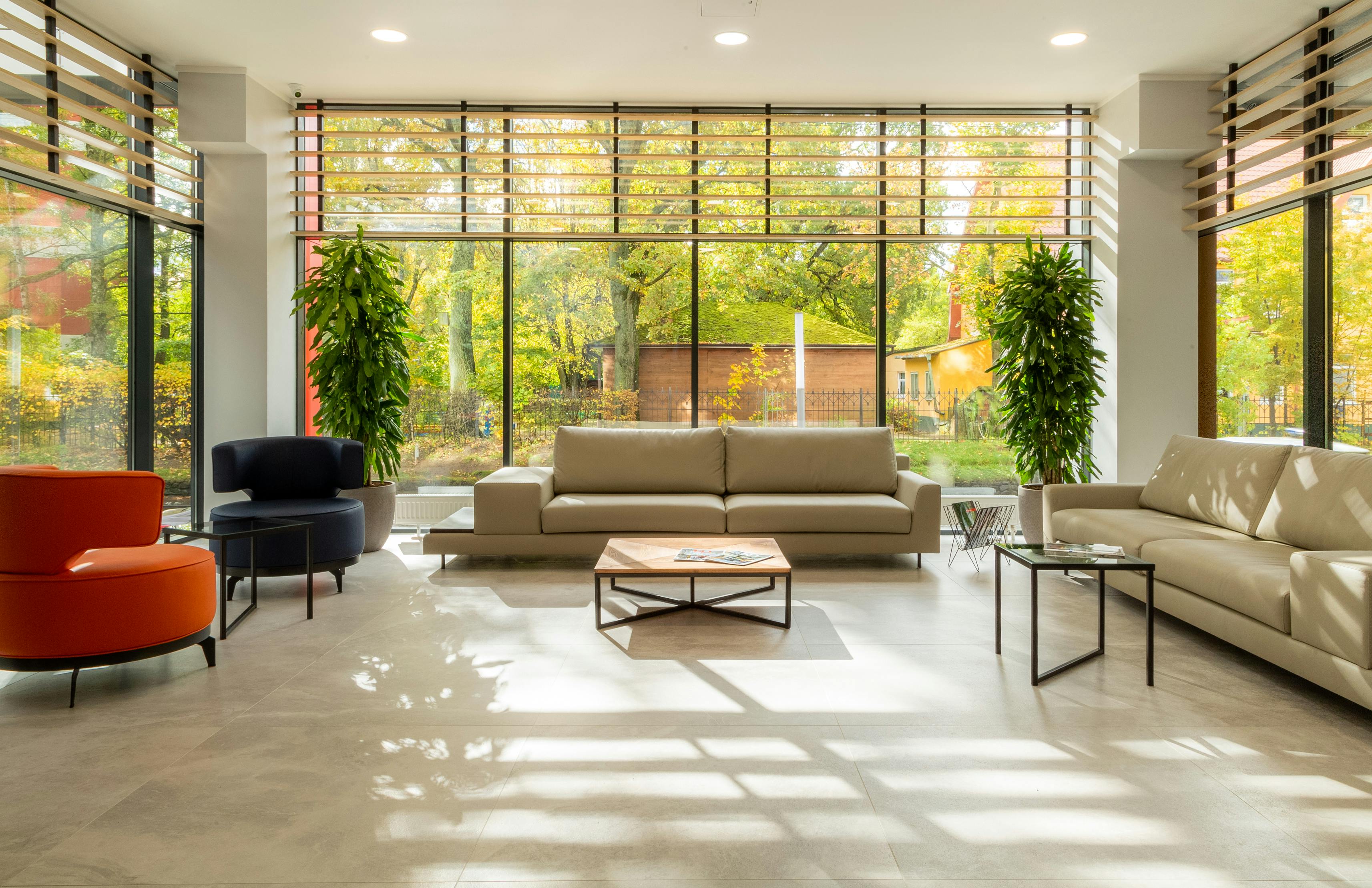 Contemporary lounge area with high windows and natural light, reflecting the high-quality facilities offered by specialised sober living solutions.