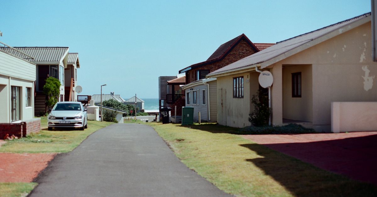 Scenic view of a quiet residential street with houses and parked car, South Africa.