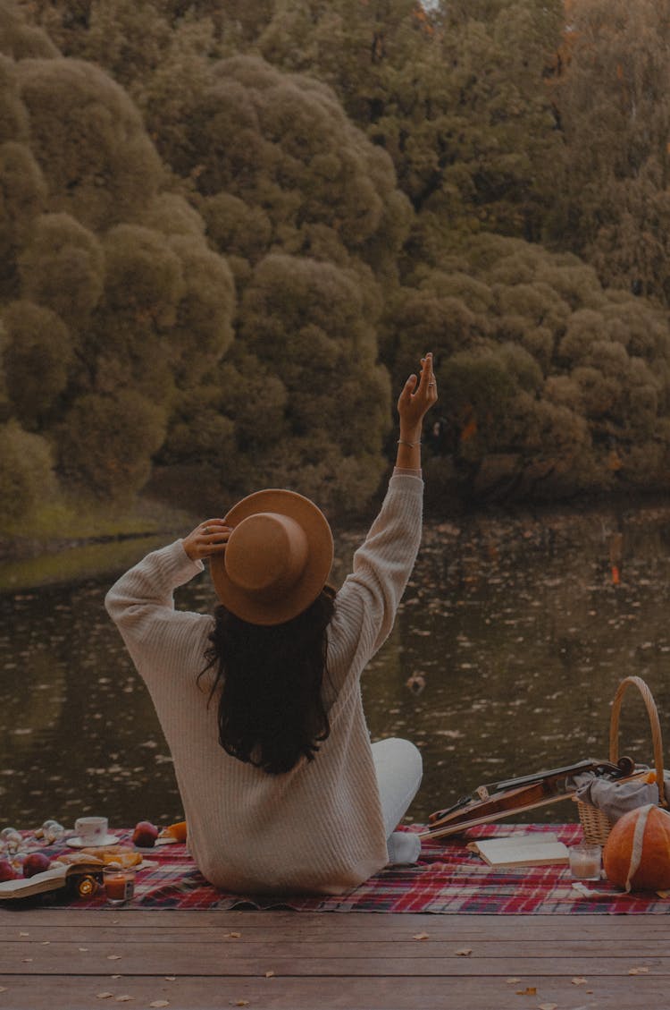 Black Haired Woman Sitting On Pier On Lake