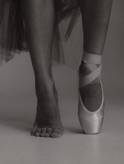Free Close-up black and white image of a ballerina's feet, one barefoot and one in pointe shoe. Stock Photo