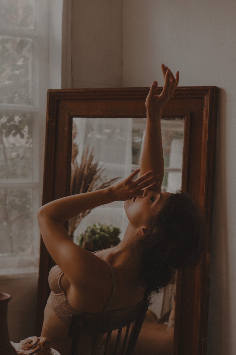 Woman Leaning Back On Chair With Arms Raised