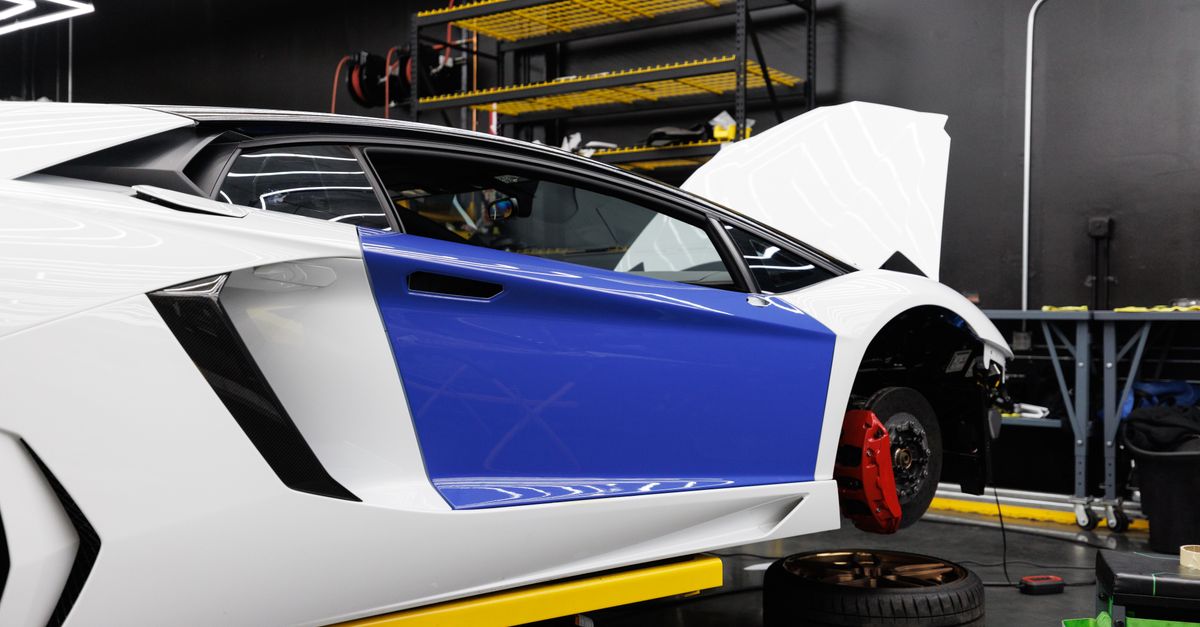 A luxury sports car being serviced inside a modern auto repair shop.