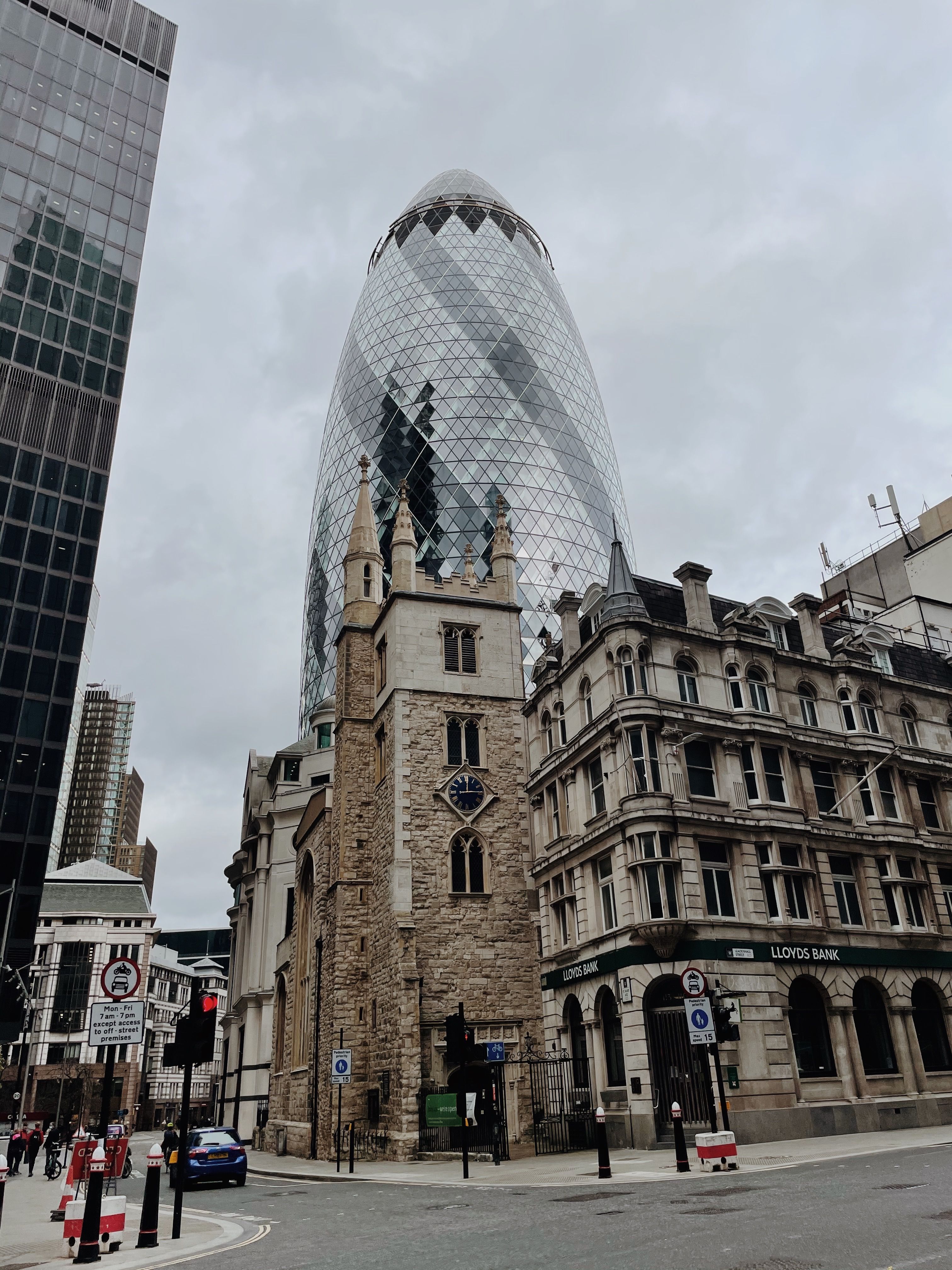 Contrast of modern Gherkin with historic buildings in London's financial district.