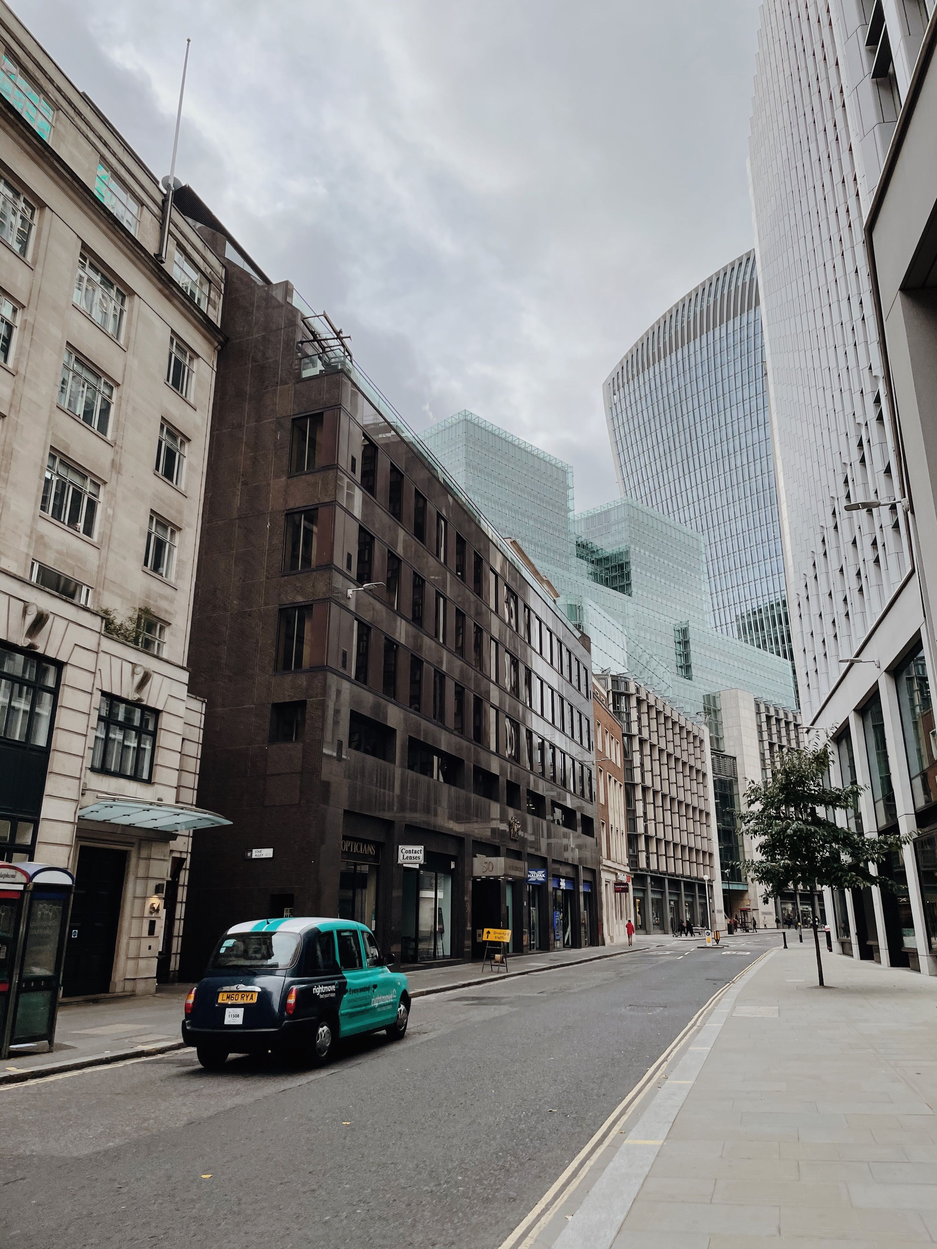 View of urban city street featuring modern skyscrapers and a classic taxi.