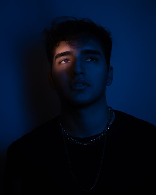 Free Dramatic portrait of a man with moody blue lighting and shadow emphasis. Stock Photo
