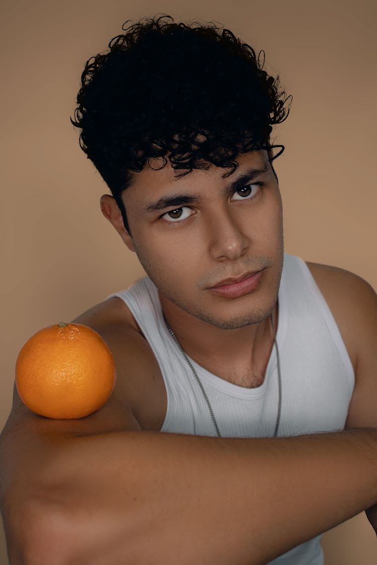 Portrait Of Brunette Man With Orange On Arm