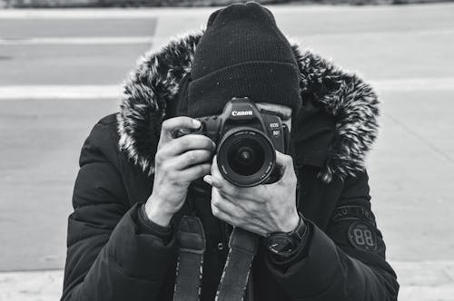 Grayscale Photo of a Person Taking a Photo