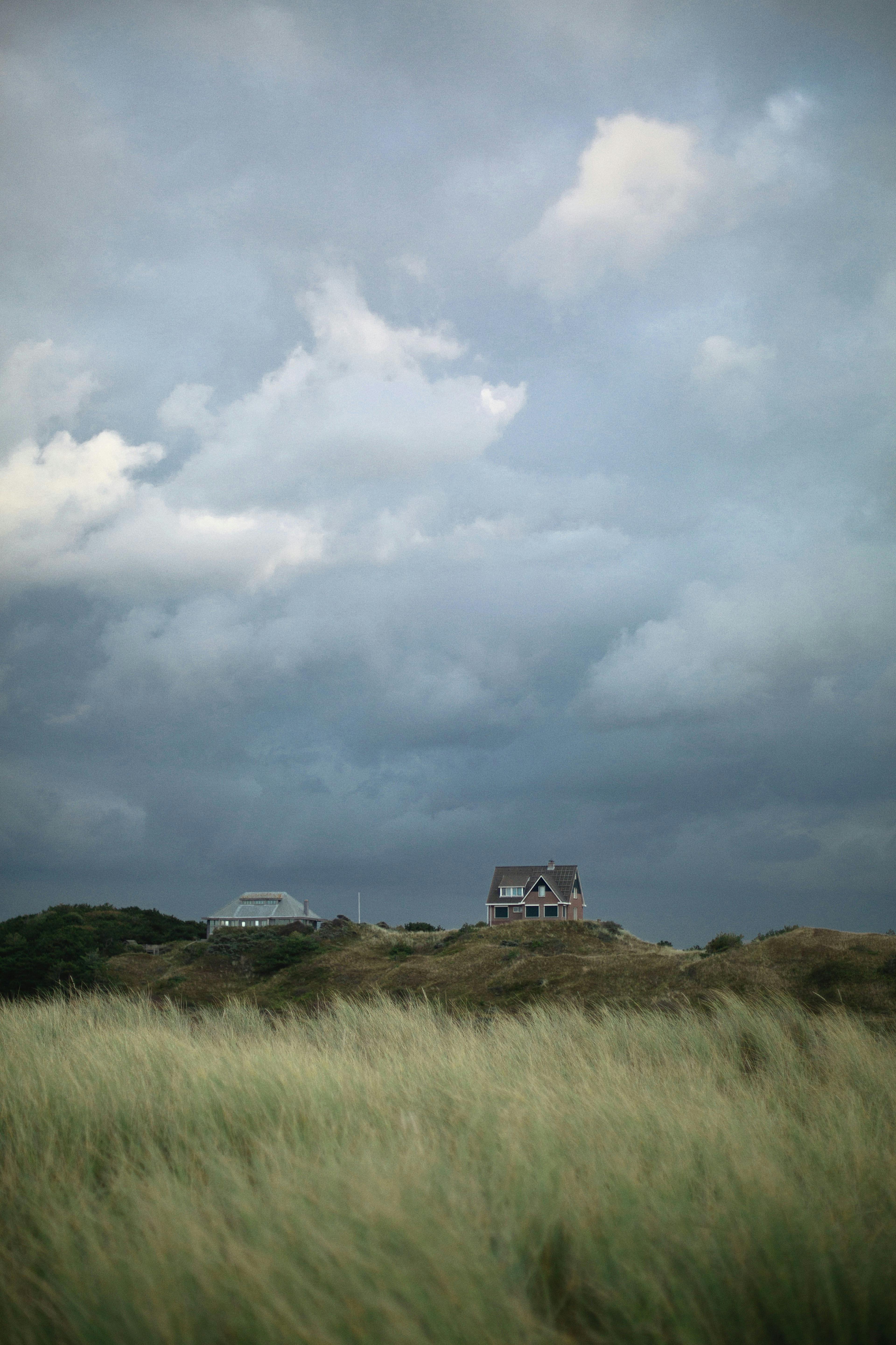 Beautiful view of the Dutch countryside under a dramatic cloudy sky, with houses in the distance.