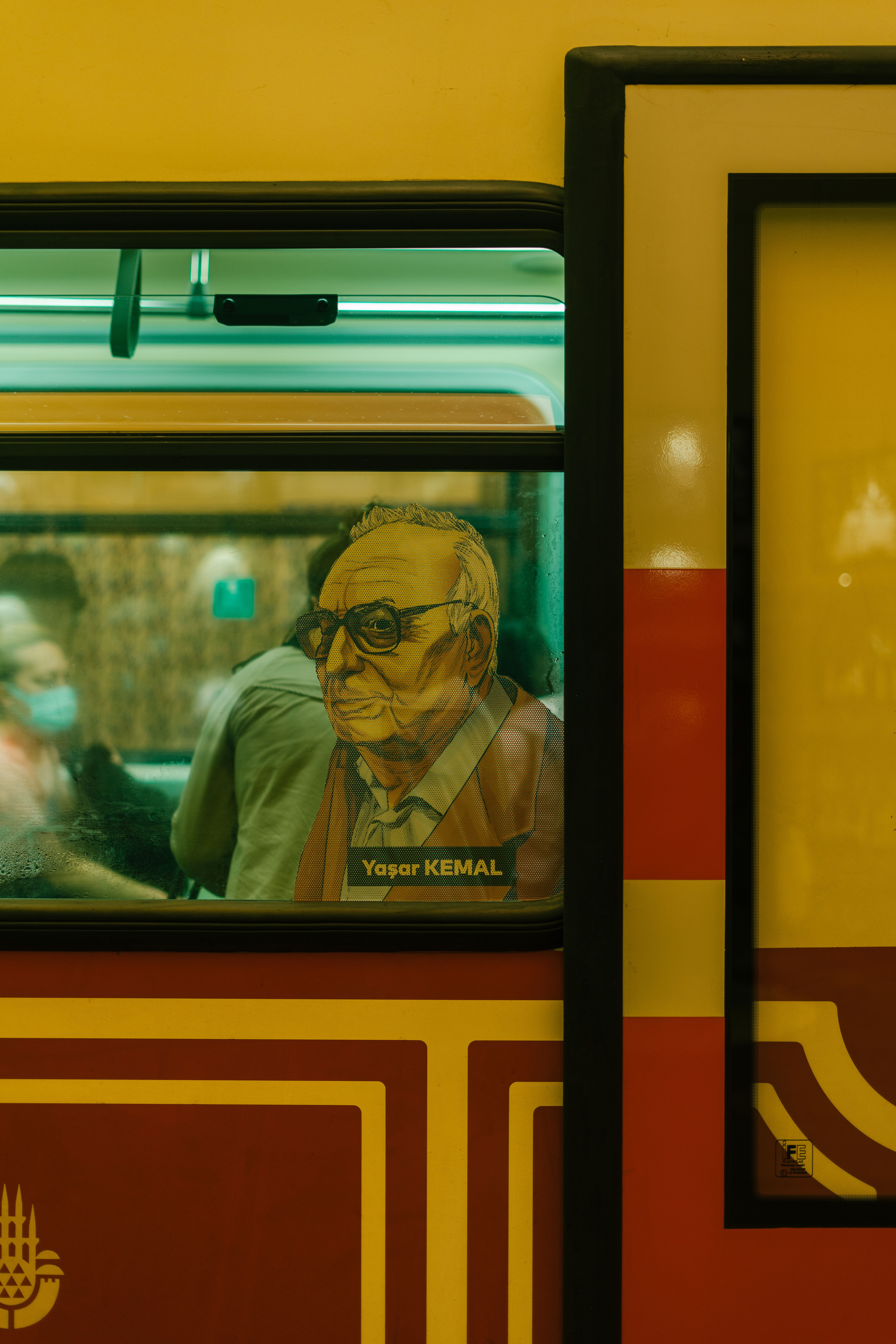 Captured image of İstanbul tram featuring Yaşar Kemal's art against a vibrant urban backdrop.