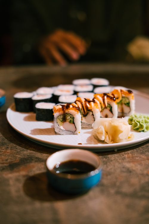 Free A close-up of a sushi platter garnished with wasabi and soy sauce on a rustic table. Stock Photo