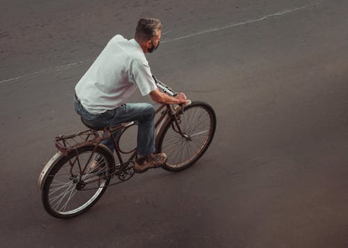 A Man Wearing Face Mask while Riding a Bike