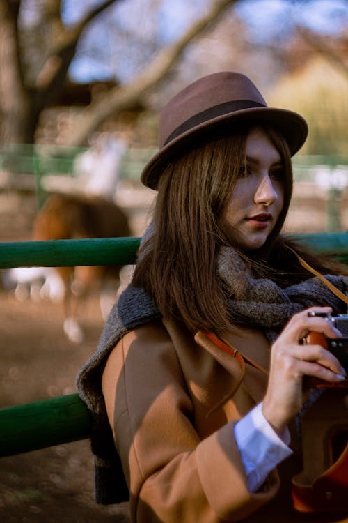 A Woman in Brown Coat and Brown Fedora Hat
