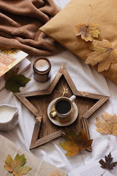 Warm autumn scene with coffee cup, leaves, and cozy decor on a star-shaped tray.