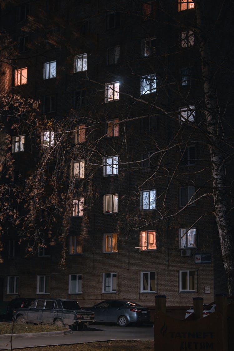 Brown Concrete Building With Illuminated Windows During Night Time