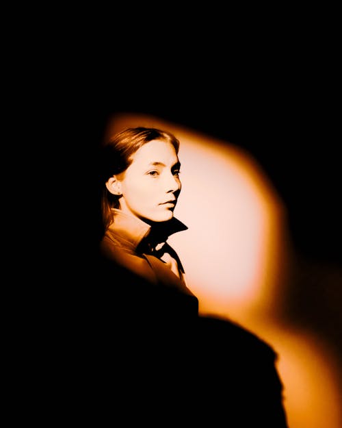 A Woman Lit by a Spotlight in the Dark Room