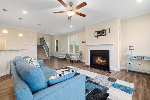 Free A well-designed modern living room featuring a warm fireplace and elegant blue sofa, highlighting comfort and style. Stock Photo