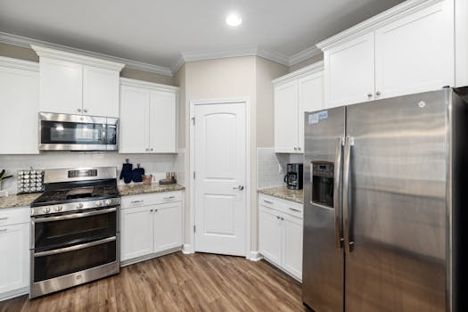 Bright and modern kitchen interior featuring stainless steel appliances and white cabinets.
