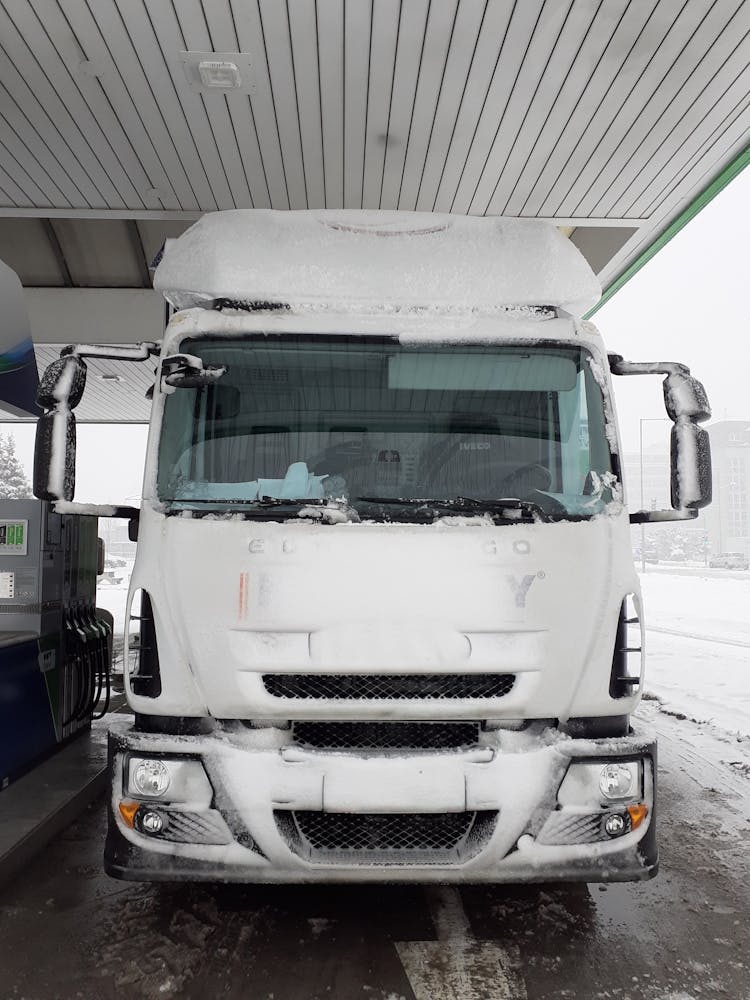 A Truck Covered With Snow On A Gasoline Station