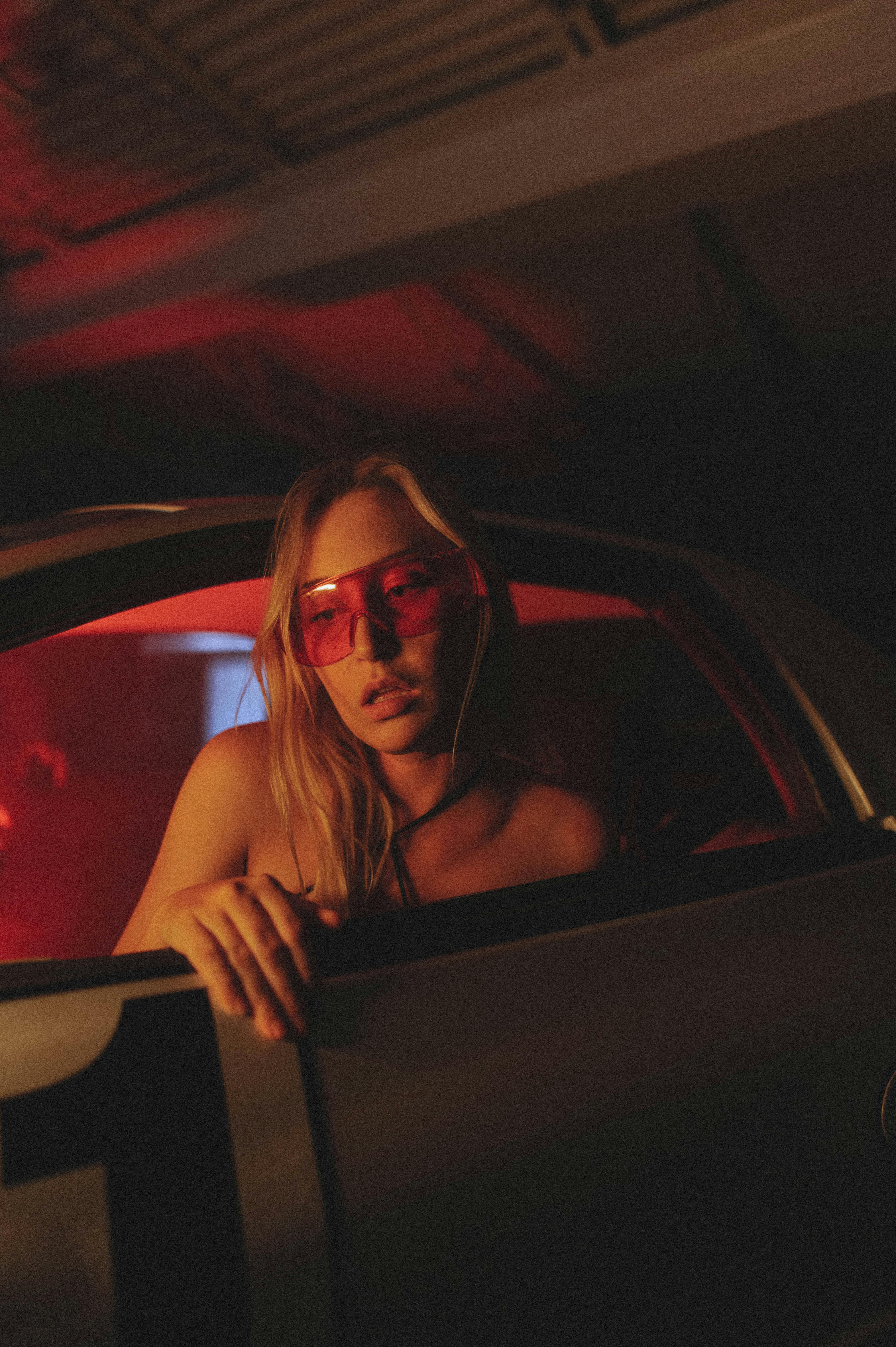 woman in red eyeglasses in car window