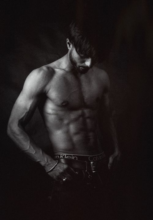 Free Artistic black and white image of a muscular man posing confidently. Stock Photo