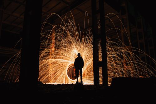 Free A striking silhouette against a dramatic steel wool light painting in an urban setting. Stock Photo