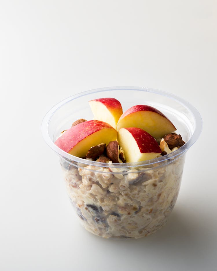 A Meal On A Plastic Container With Apple Slices On Top