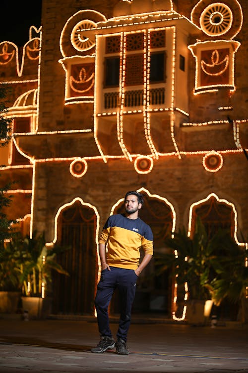 A Man Standing Near a House Full of Lights