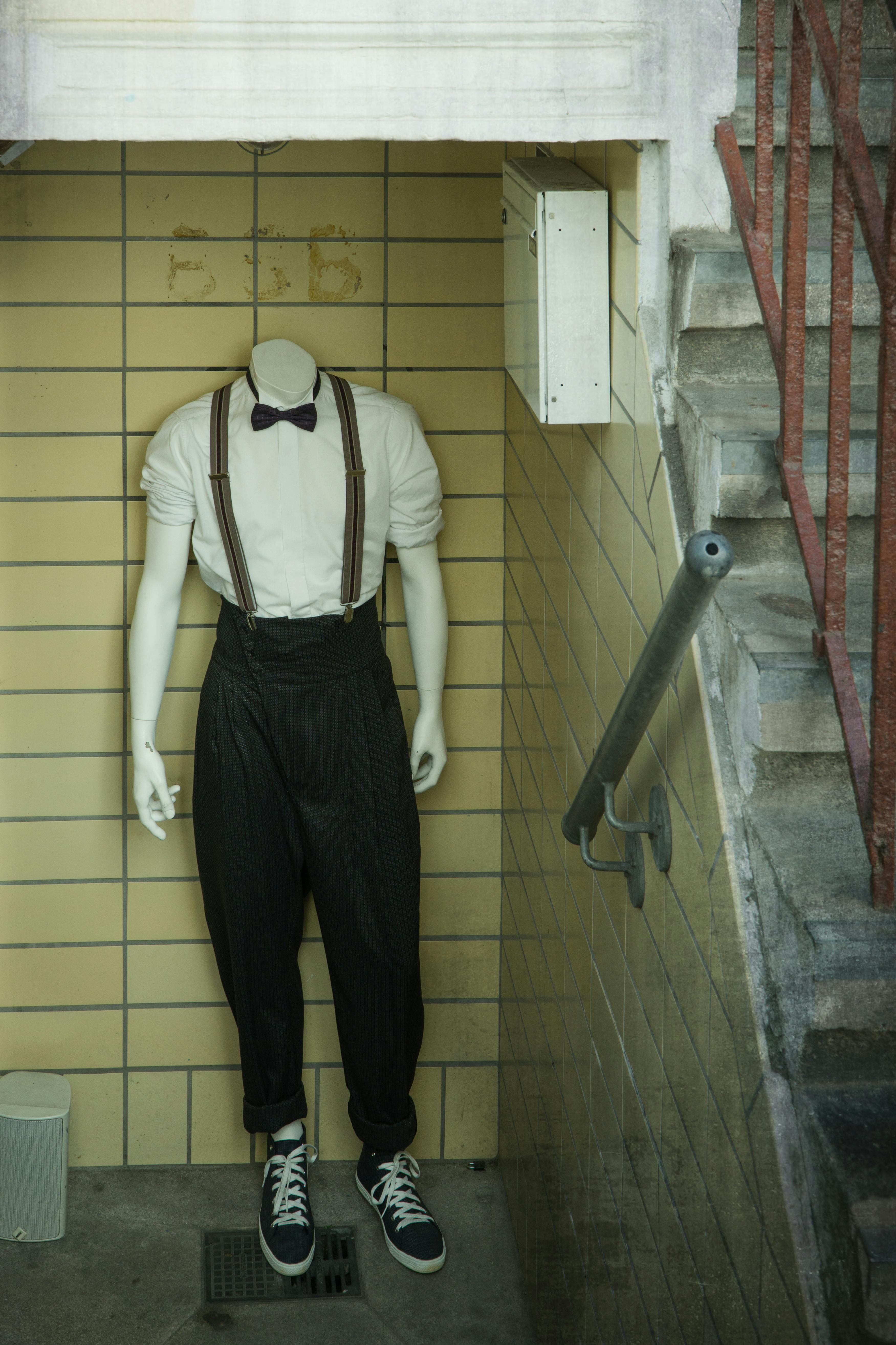 楼梯上，打着领结的时尚人体模型展现出都市气息的大胆服装